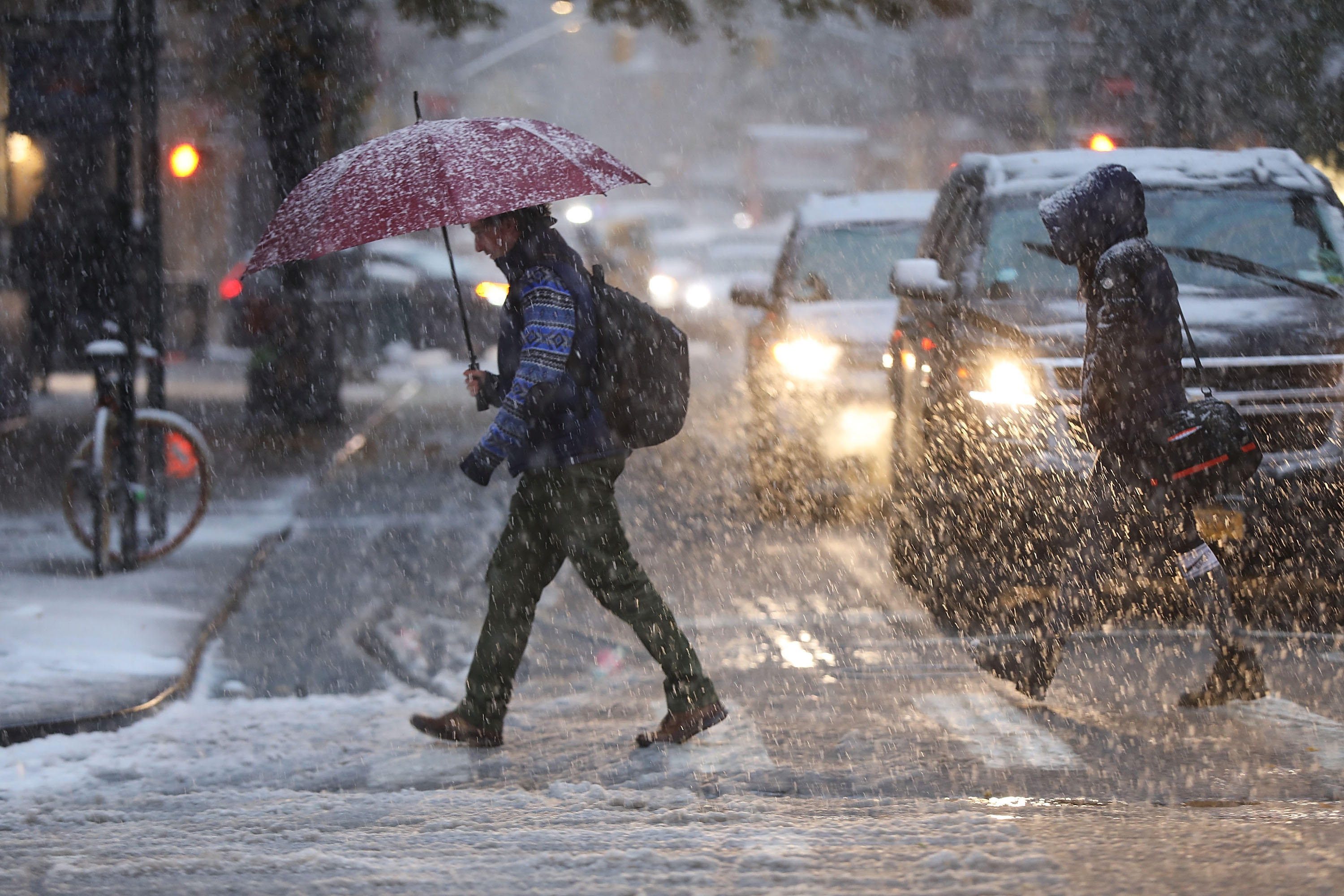 NEW YORK, NY - NOVEMBER 15: Para pejalan kaki ngliwati campuran salju lan es ing Manhattan tanggal 15 November 2018 ing New York City. New York ngalami snowfall pisanan ing mangsa ana karo pangarepan saka liwat inchi saka salju tiba ing wilayah. (Foto dening Spencer Platt / Getty Images)